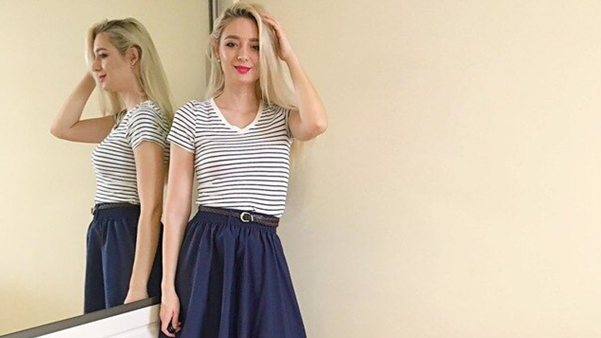 Doina wearing a dark navy blue mid-size skirt with a dark brown belt and a top